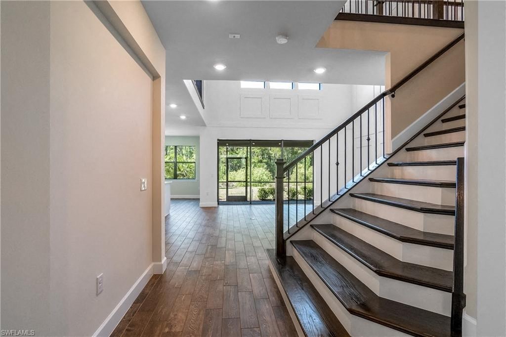 the entryway of a house with a staircase and wooden floors
