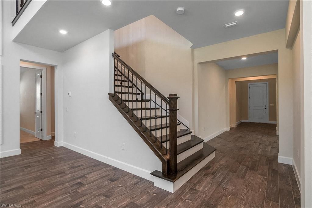 a staircase in a new home with a wooden floor and white walls
