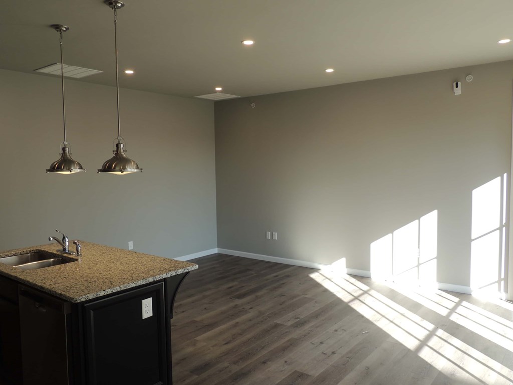 an empty living room with a sink and a window