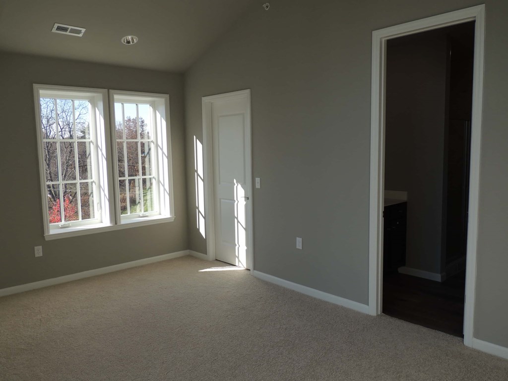a empty living room with a door and window