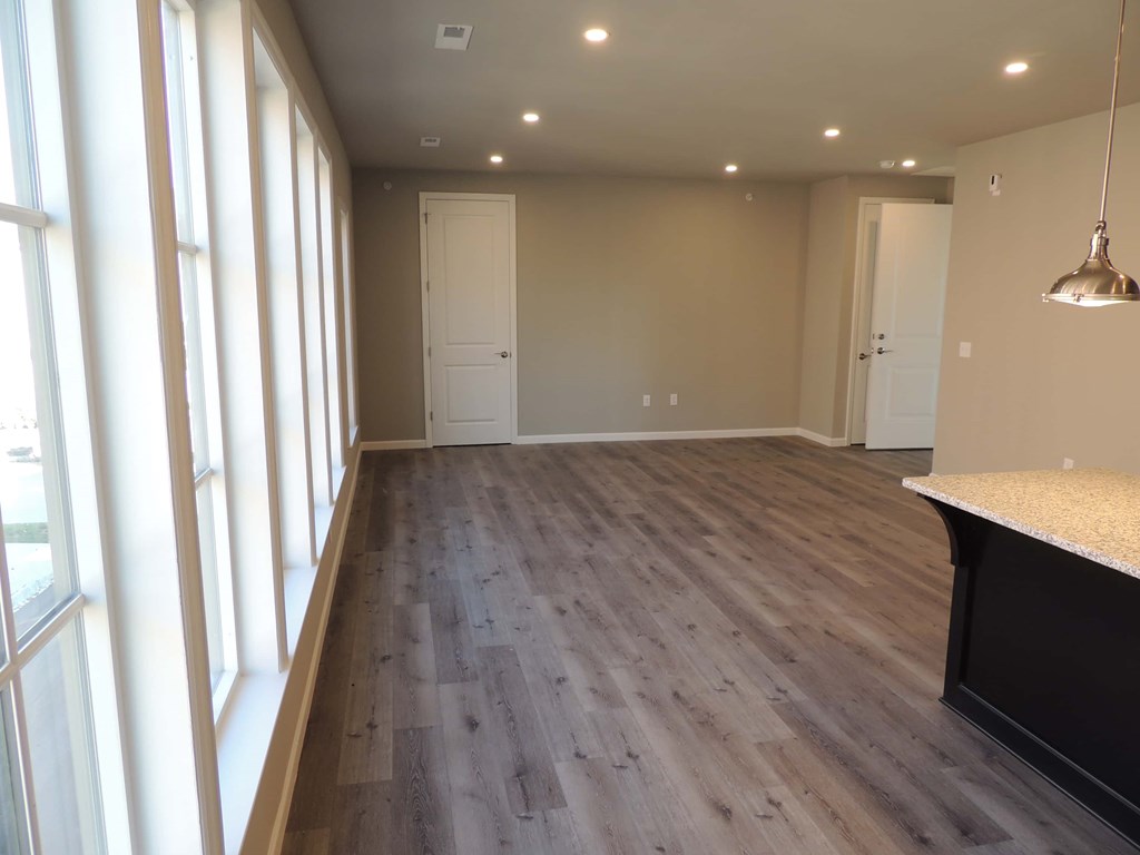 a renovated living room and dining room with wood flooring