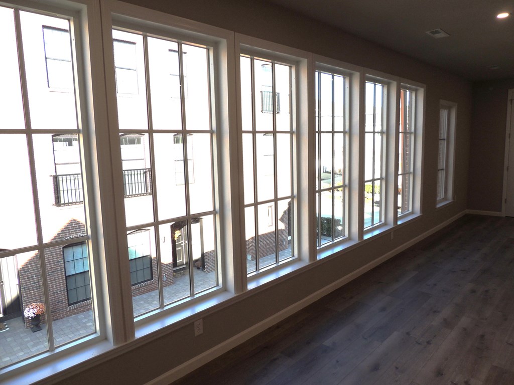 a living room with large windows and a wooden floor