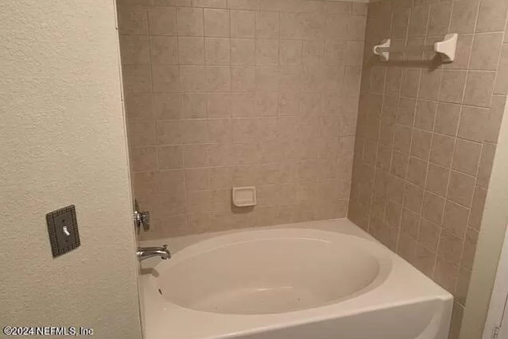a bathroom with a white tub and a sink