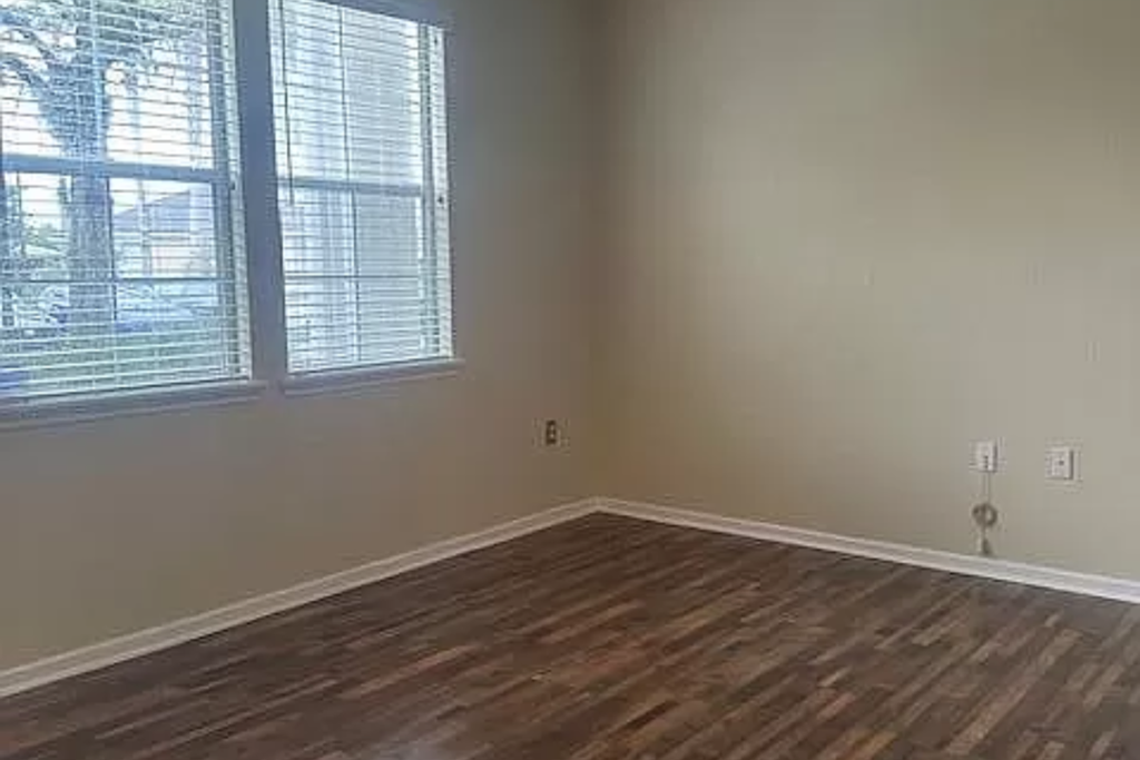 a empty room with a window and a wooden floor
