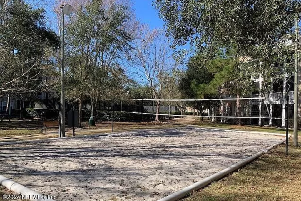 a volleyball court in a park with trees
