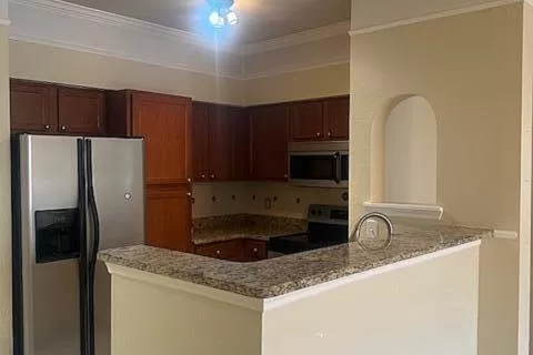 a kitchen with a granite counter top and a refrigerator