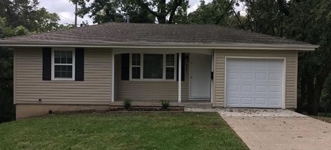 A small house with a white garage door.