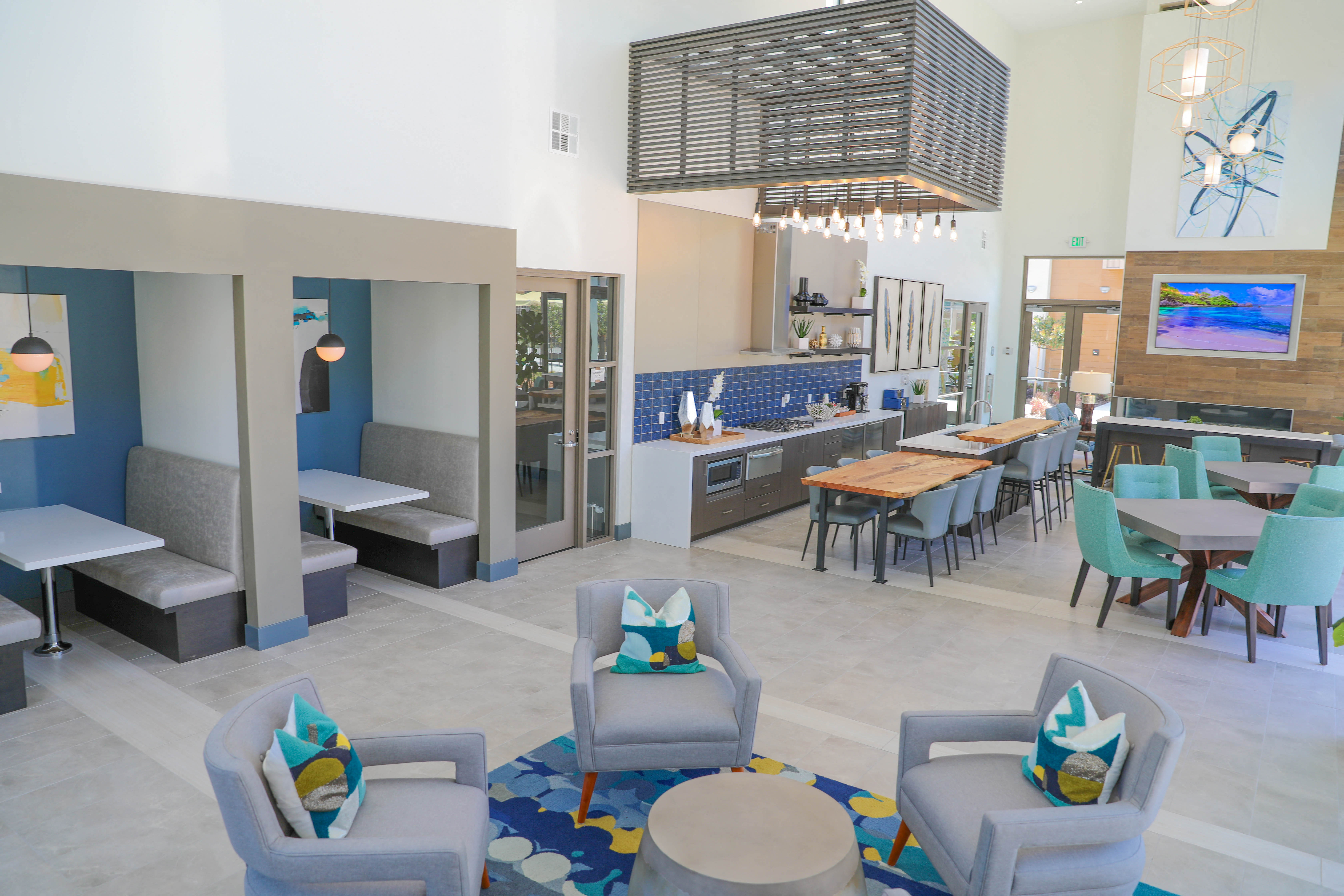 A modern living room with grey chairs and a blue couch.