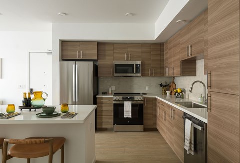 A modern kitchen with wooden cabinets and stainless steel appliances.
