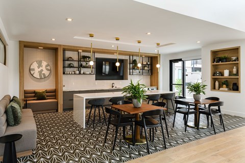 A modern dining room with a patterned floor and a wooden table surrounded by chairs.
