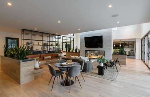 A modern living room with a fireplace and a dining table set up.