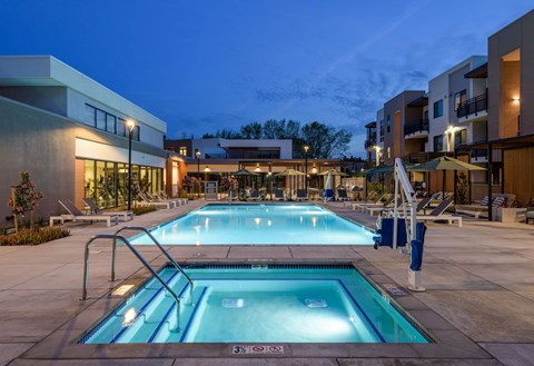 A large outdoor swimming pool with a diving board and a slide.