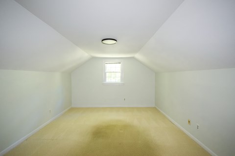 an empty room with a window and white walls