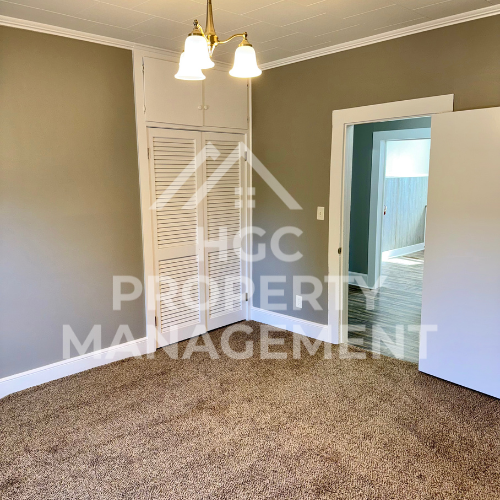 a renovated living room with a closet and a door to a bedroom
