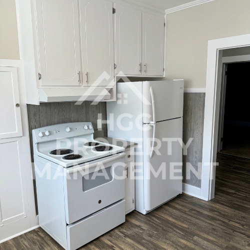 a kitchen with white appliances and white cabinets and a refrigerator
