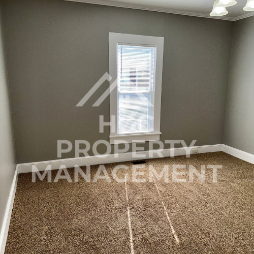 a small room with a window and a cork floor