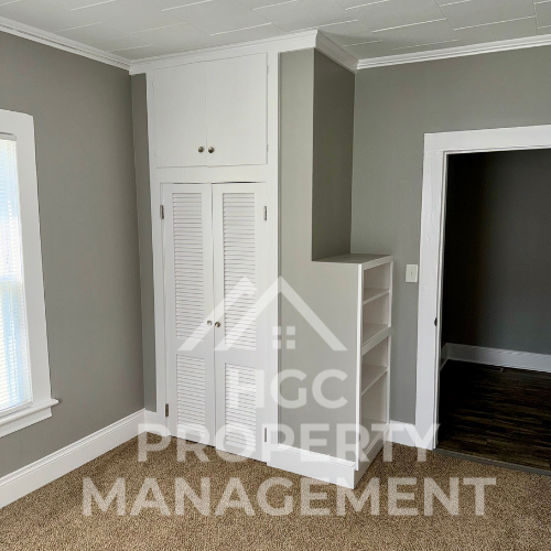 a closet and stairs in a small room with a door