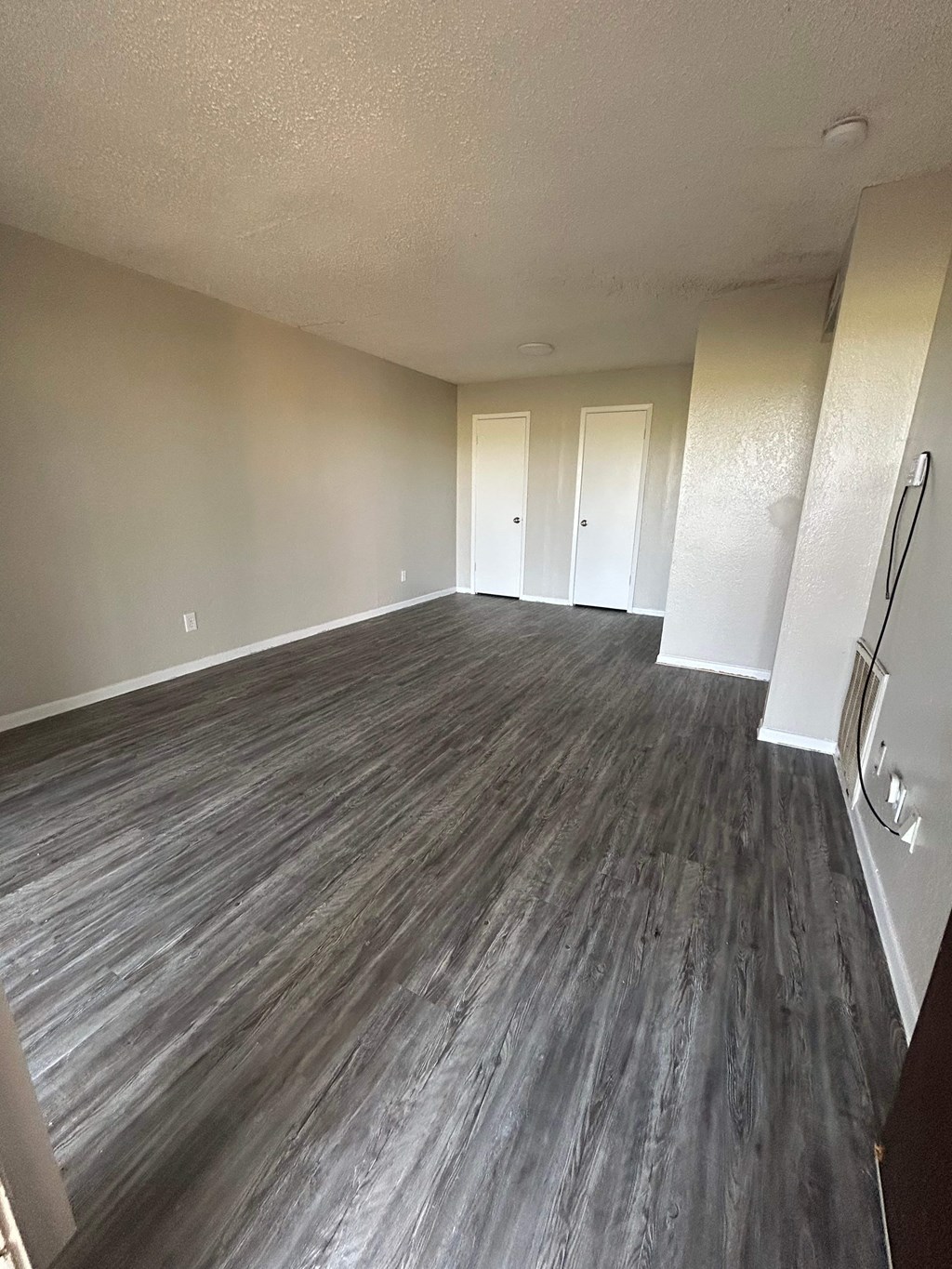 A room with wood flooring and white walls.