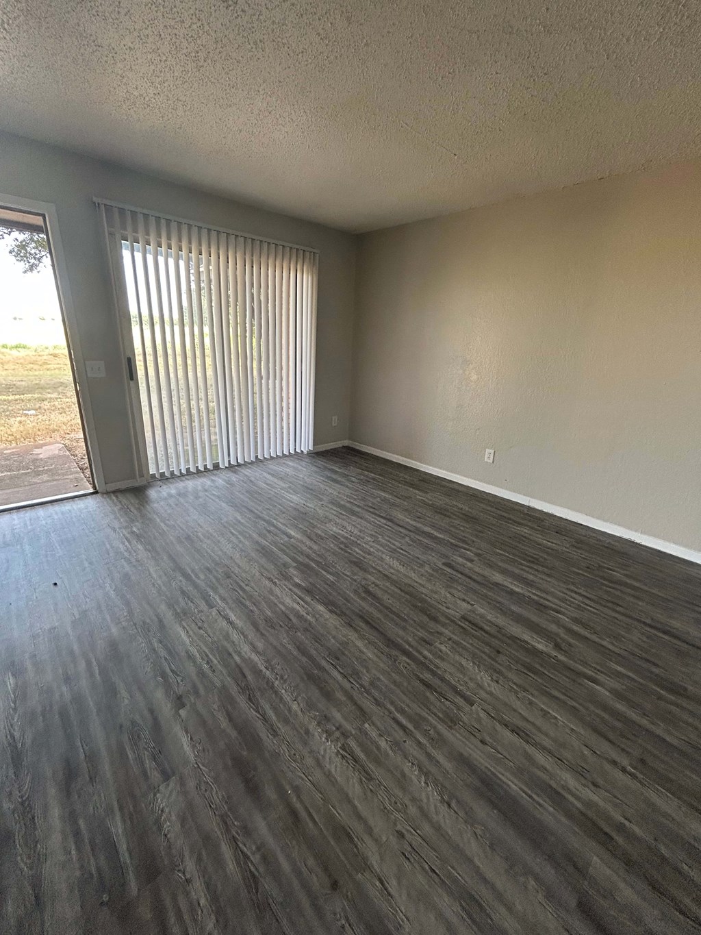 A room with a sliding door and wood flooring.