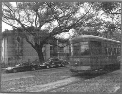 A black and white photo of a tram on a city street.