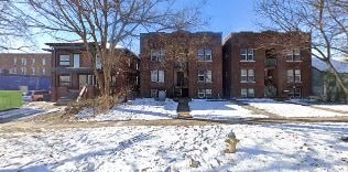 a snow covered yard in front of a building