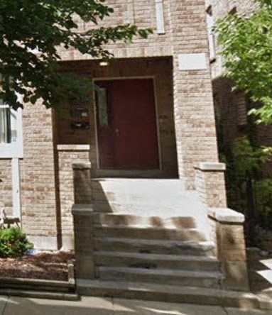 a brick building with a red door and stairs