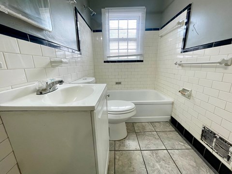 A white sink and toilet in a bathroom with black and white tiles.