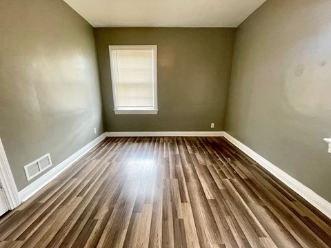 A room with wooden flooring and a window.