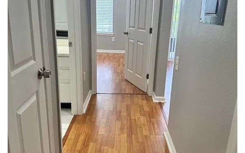 a hallway with two doors and a hard wood floor