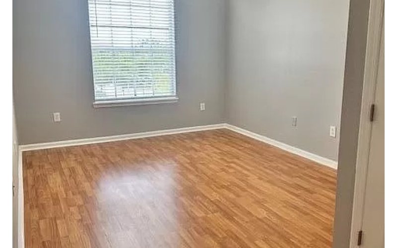 an empty room with a wooden floor and a window