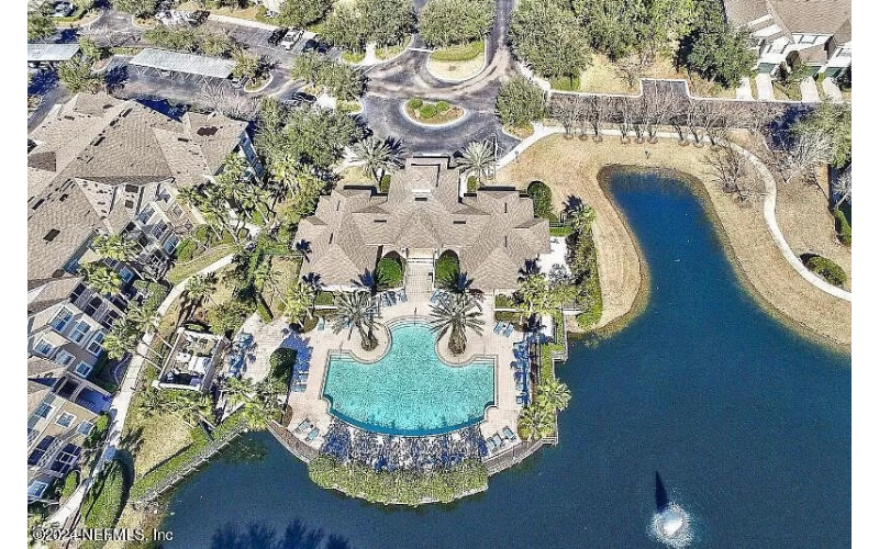 an aerial view of a resort with a pool and a lake