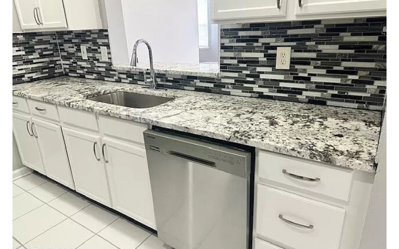 a kitchen with white cabinets and a sink
