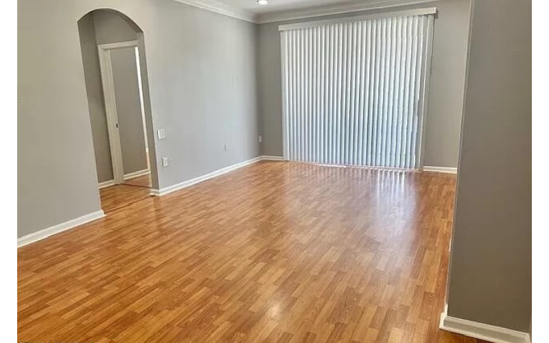 an empty living room with a wood floor and a window