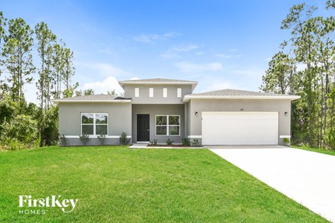 a white house with a lawn and a garage