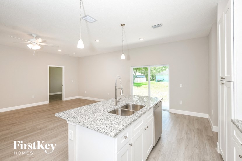 a kitchen with white cabinets and a granite counter top