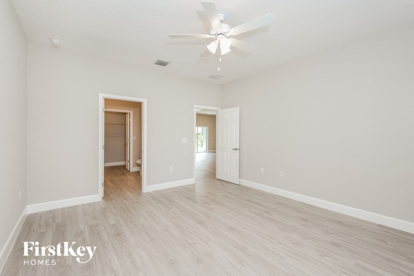 a spacious living room with white walls and wood floors