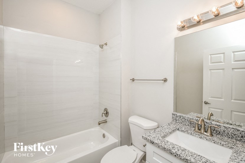 a white bathroom with a white toilet and a tub and a sink