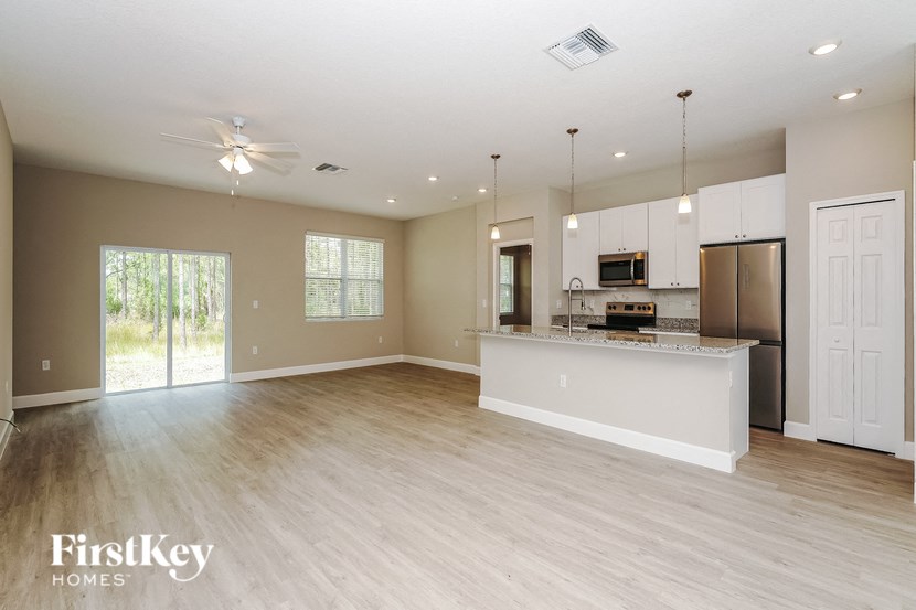 an open kitchen and living room with a kitchen island and stainless steel appliances