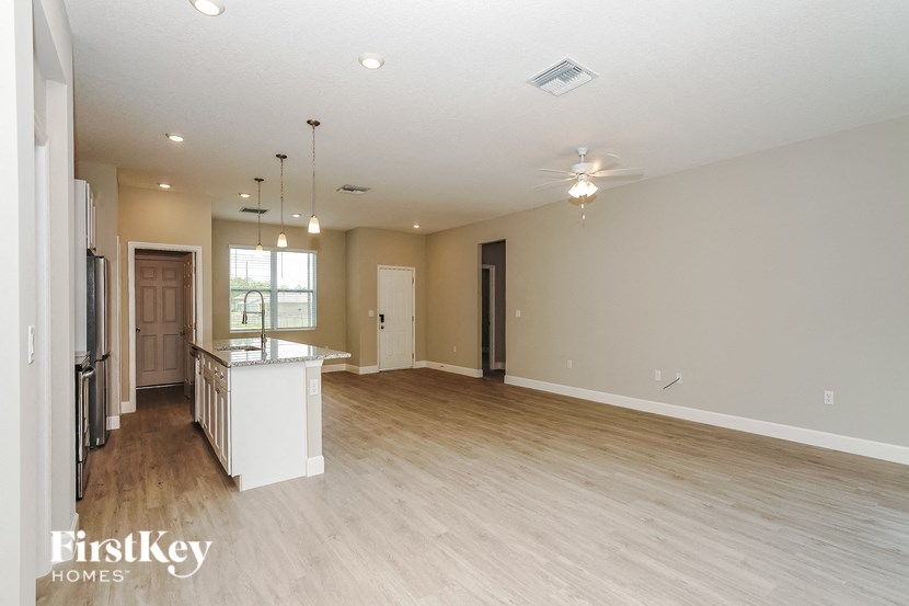 the living room and kitchen of an empty house