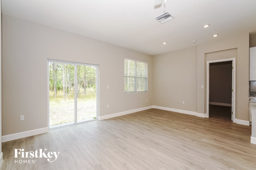 a living room with a wooden floor and a sliding glass door