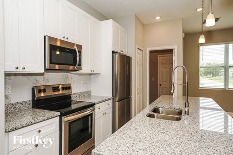 a kitchen with granite counter tops and stainless steel appliances