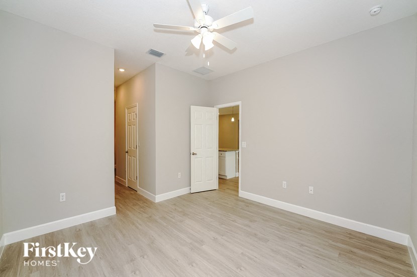 a spacious living room with a ceiling fan and wood flooring