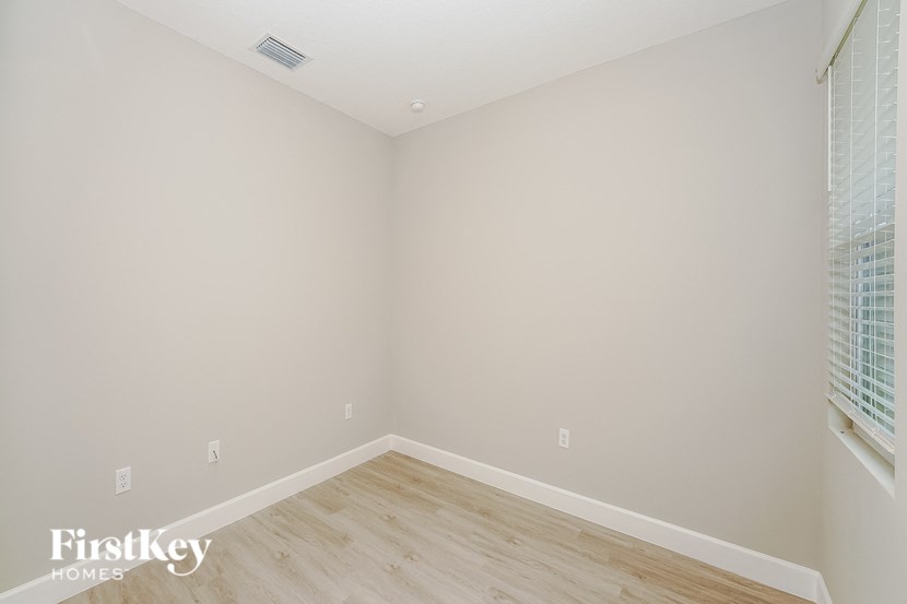 a bedroom with a wood floor and white walls