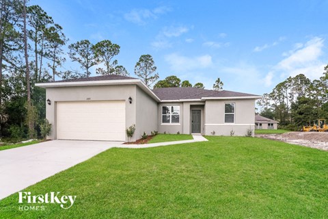 a beige house with a lawn and a garage