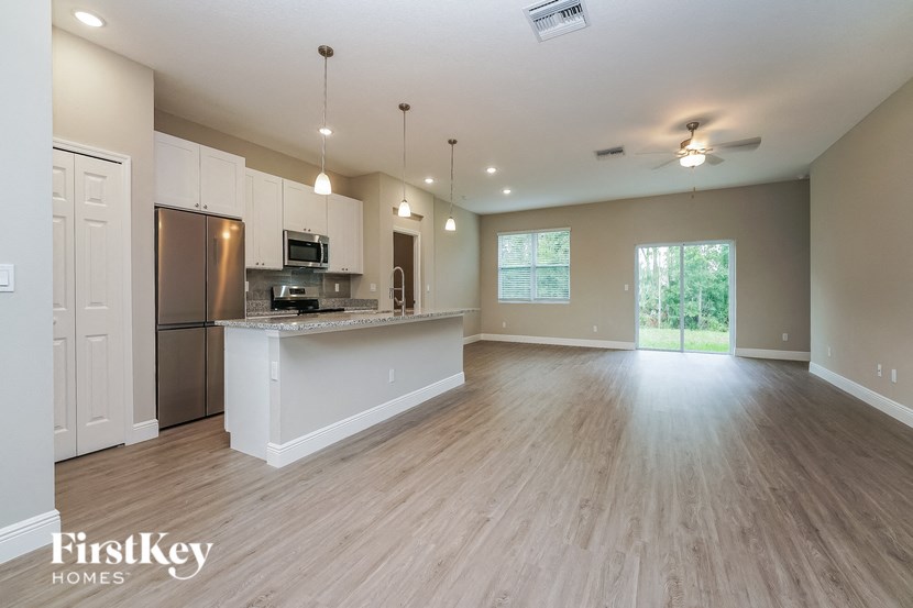 an open kitchen and living room with a kitchen island and stainless steel appliances