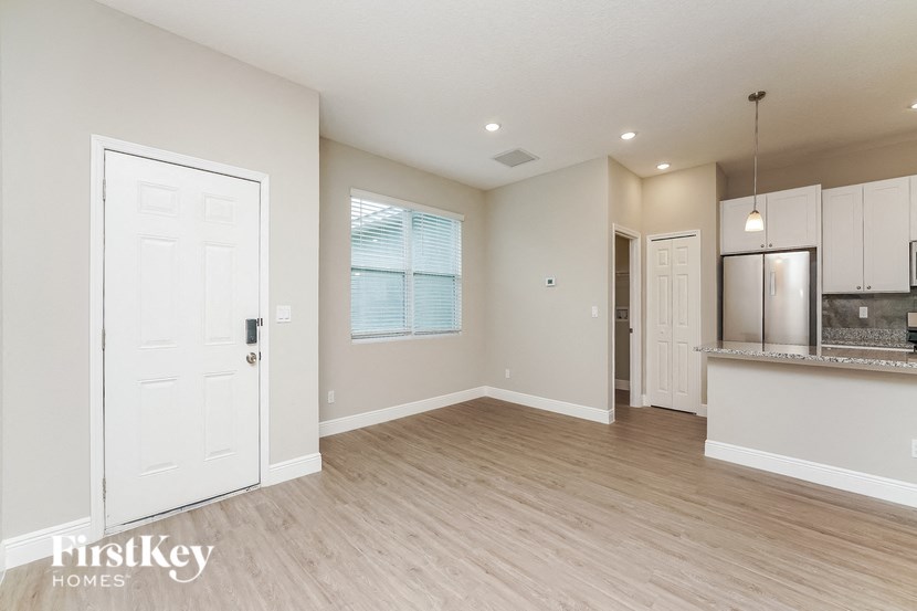 a kitchen and living room with a refrigerator and a door