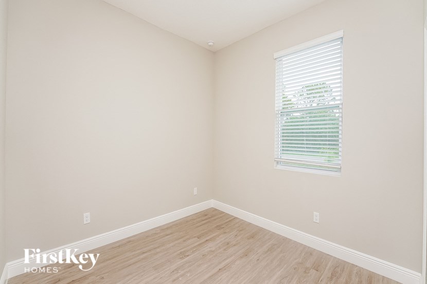 a bedroom with wood floors and a window