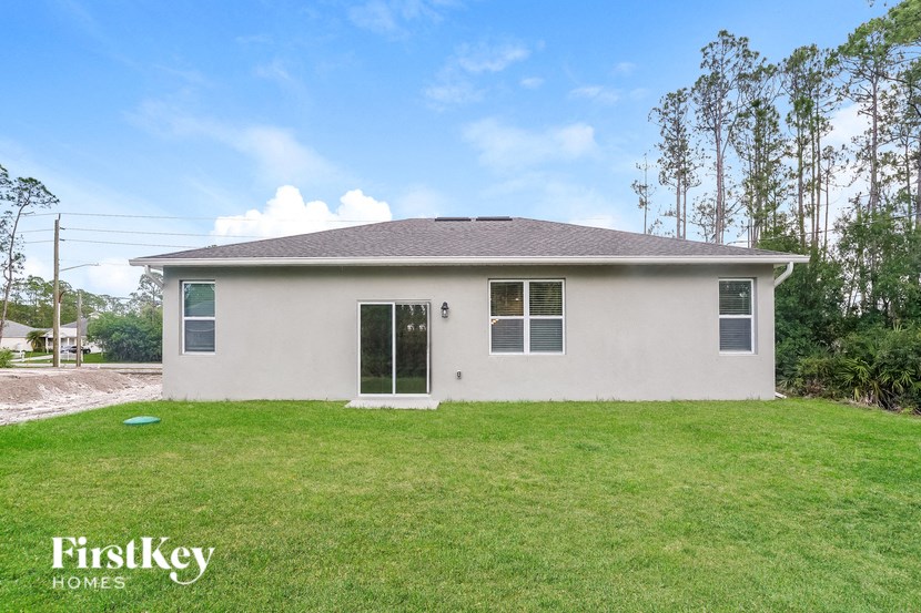 a white house with a grassy yard and a driveway