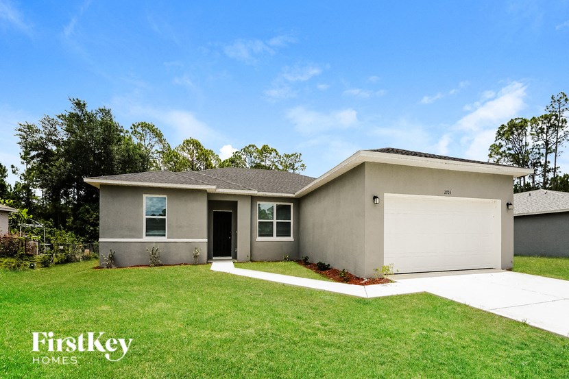 a beige house with a lawn and a garage door