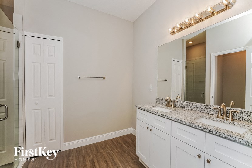 a bathroom with white cabinets and a sink and a mirror